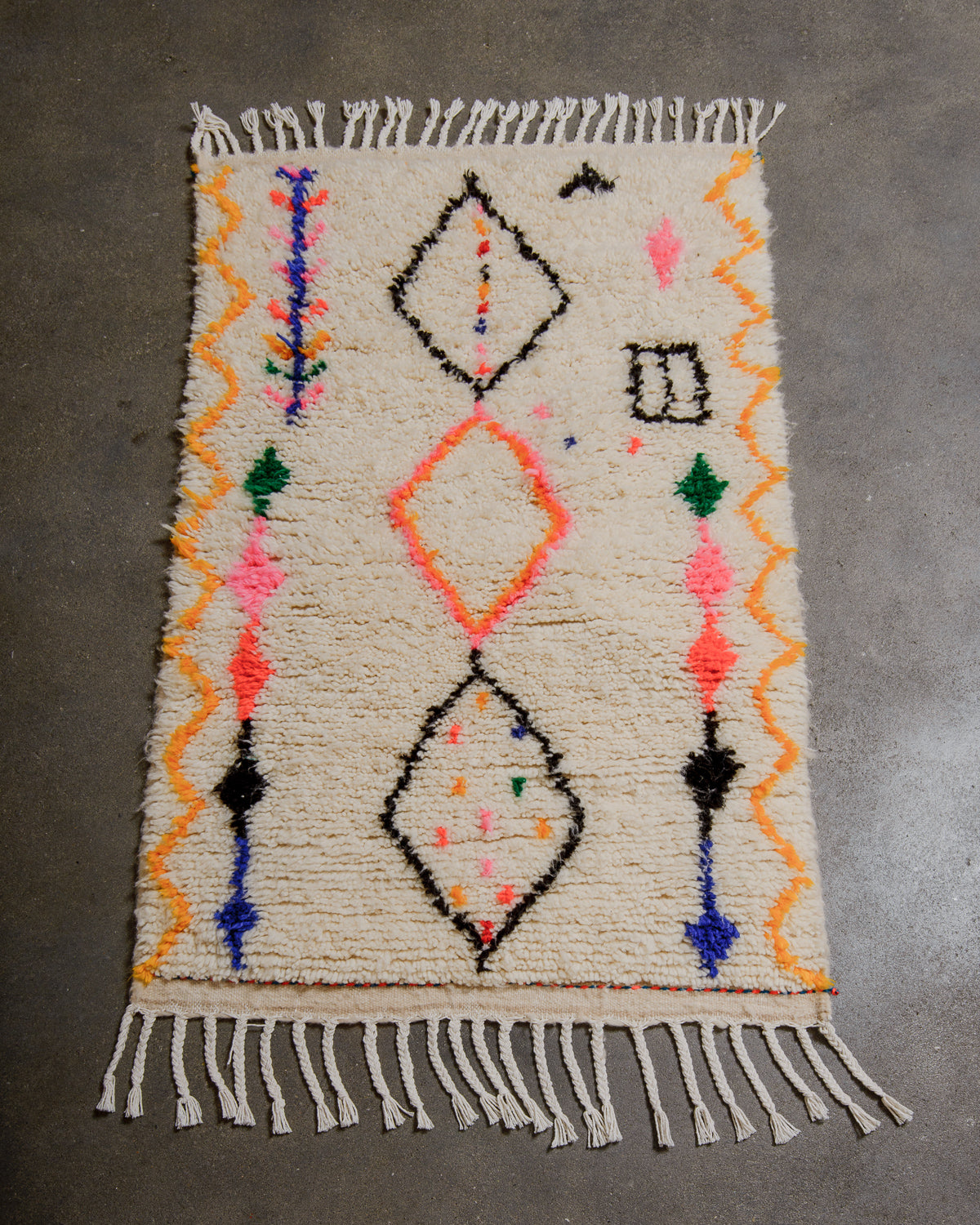 Azilal rug with geometric patterns on a gray surface